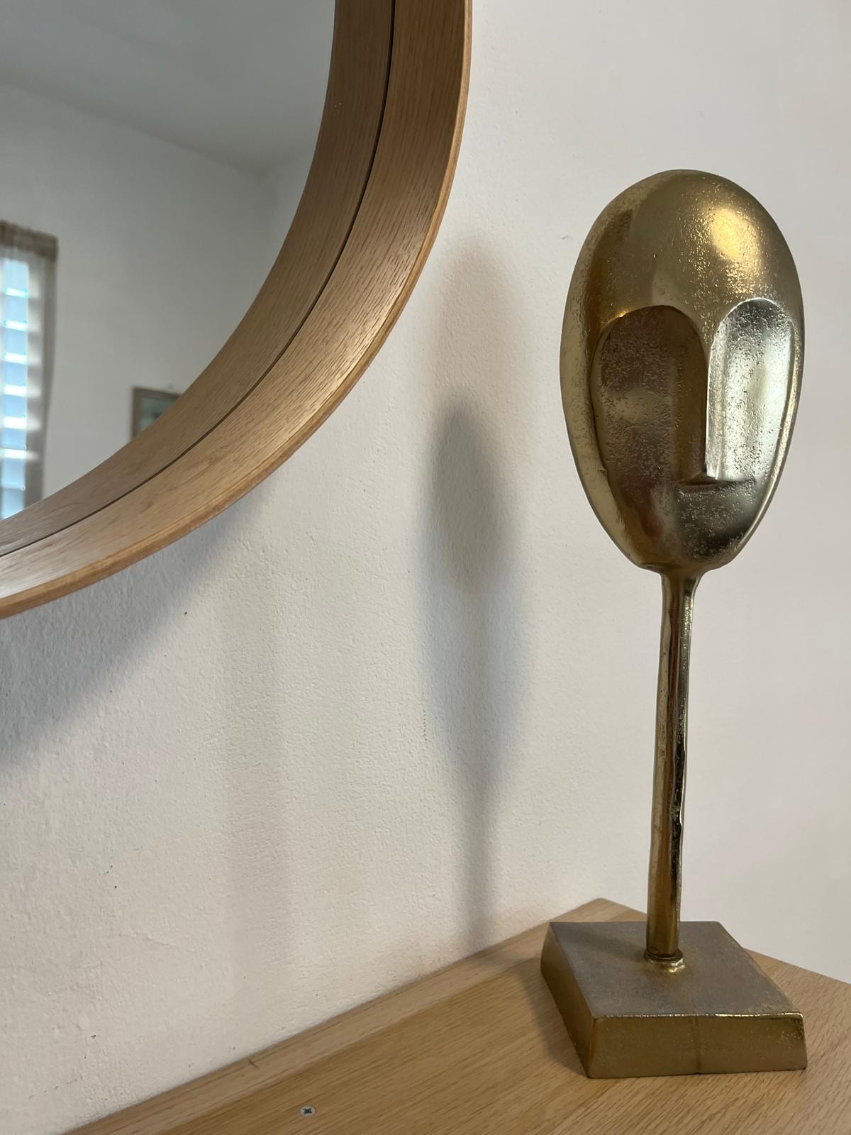 Brass sculpture detail beside an oak mirror